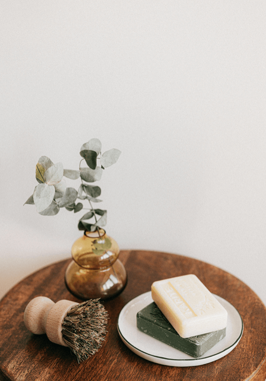 wellness-products Wellness products, a body brush and soap on a wooden table.
